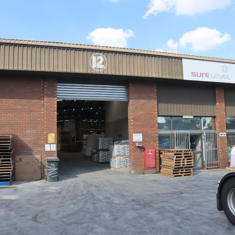 A truck loaded with general purpose cement is parked in front of a warehouse, indicating a commercial setting for transportation and storage purposes.